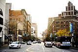 A downtown city street with cars driving